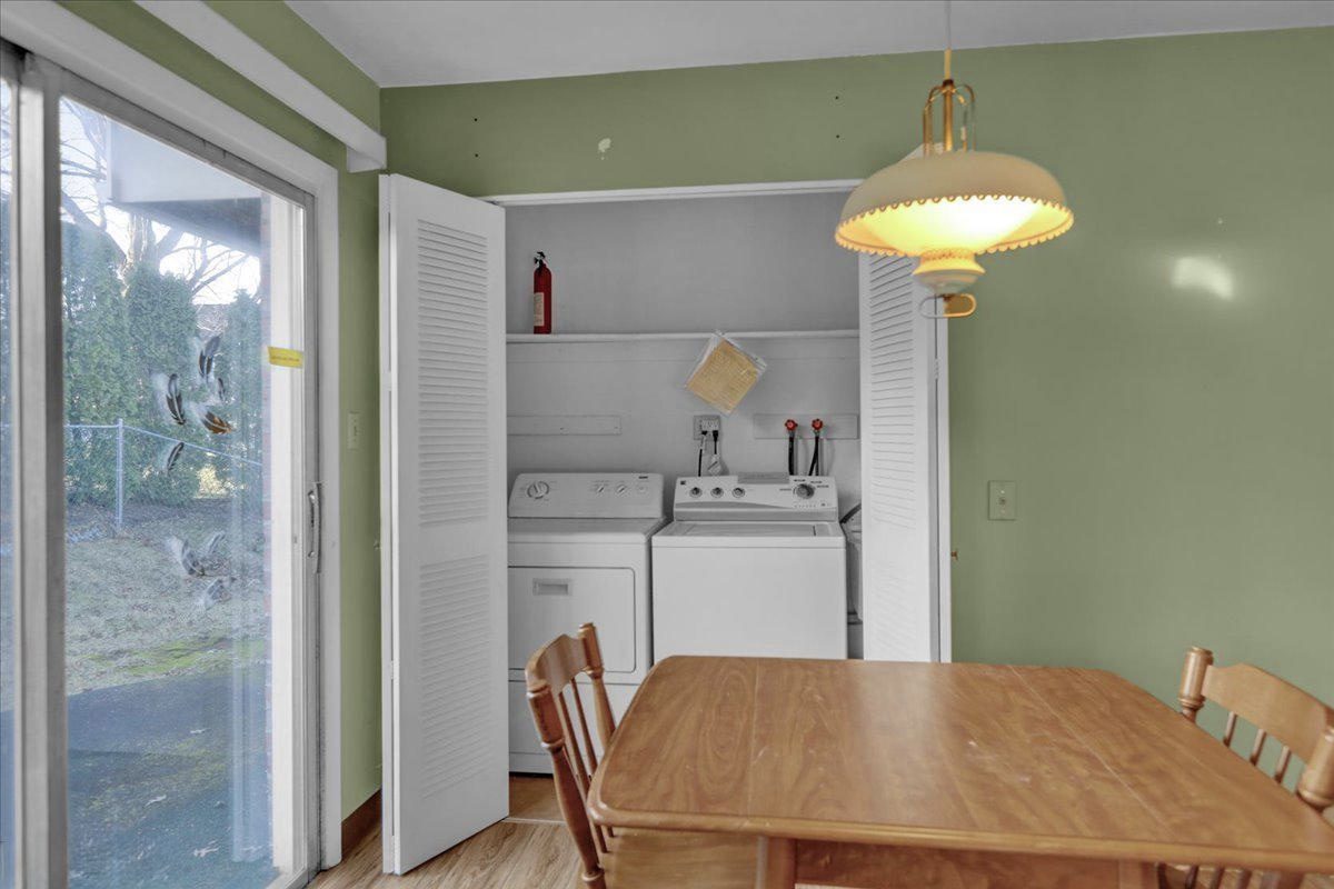Before: a washer and dryer in a louvered-door closet beside a sliding glass door and dining table