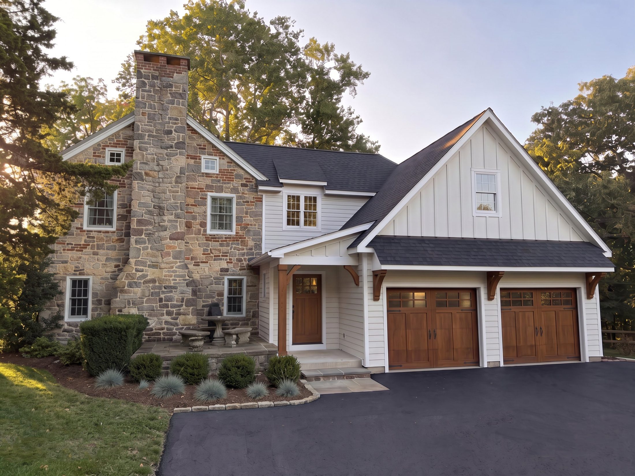 Stone farmhouse with a new two-car garage addition: board-and-batten gable, cedar brackets and stained wood garage doors
